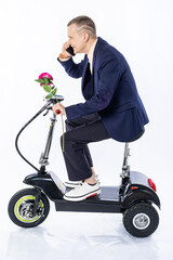 a man in a suit and shirt on an electric car, a tricycle. isolated white background. office manager rides around the city, hurries to work, a date. eco-friendly transport. Earth Day