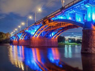 Night view of bridge across the river. Night illumination of the building.
