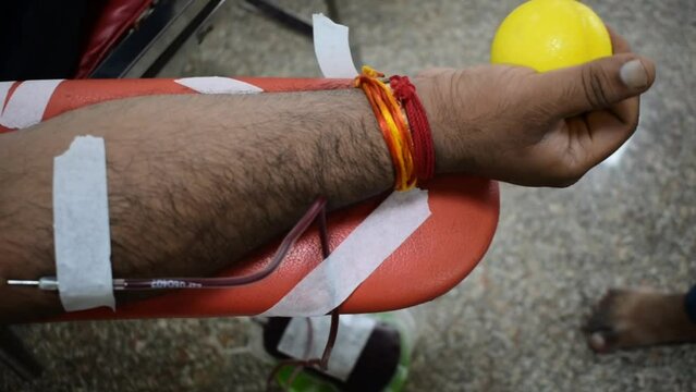 Blood donor at Blood donation camp held with a bouncy ball holding in hand at Balaji Temple, Vivek Vihar, Delhi, India. Also concept image for World blood donor day on June 14 every year