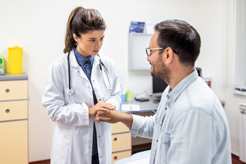 Experienced doctor discussing with patient his private medical file. Young man checking up with his MD, and consulting about the way of his health treatment and health insurance.