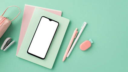 Back to school concept. Top view photo of mobile phone over copybooks pens pencil-case stapler and pineapple shaped eraser on isolated pastel green background with copyspace - Powered by Adobe