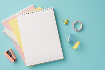 Back to school concept. Top view photo of school supplies open notepad ruler adhesive tape binder clip and stapler on isolated pastel blue background with blank space