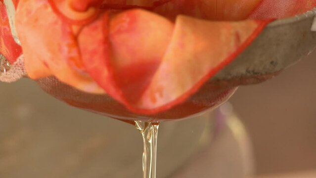 Babassu vegetable oil being filtered through a cloth as part of the homemade process