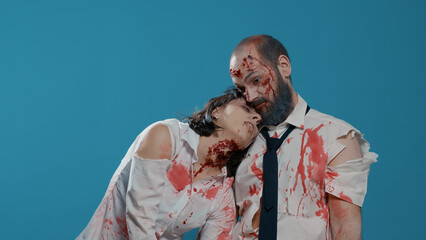Dangerous evil office zombies stretching arms to camera while standing on blue background. Bizarre looking apocalyptic brain-eating monsters with bloody scars and wounds acting weird.