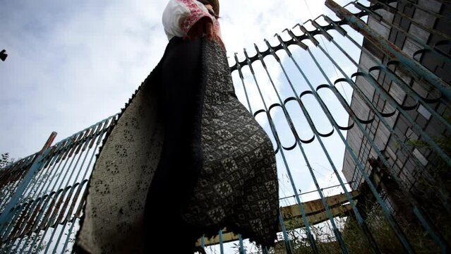 Romanian girl walks along old rusty fence - romanian factory
