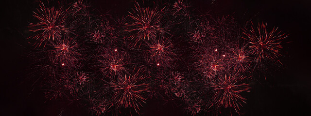 Obraz na płótnie Canvas Fireworks pyrotechnics celebration party event festival holiday or New Year background panorama - Red firework on dark night sky...