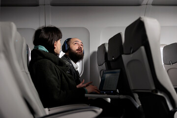 Man tourist preparing to takeoff on airplane flight, getting ready to fly with international...