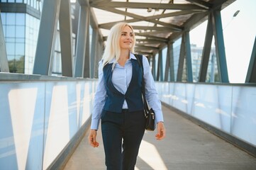 Fototapeta premium Beautiful Woman Going To Work, Business Woman Walking Near Office Building. Portrait Of Successful Business Woman.