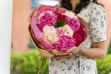 Woman holding beautiful bouquet with peonies. Florist with flowers