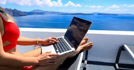 Close up of woman hand with nomad  digital freelancer as running remotely with bright scenic view of the Mediterranean Sea ,Oia -Santorini,Greece