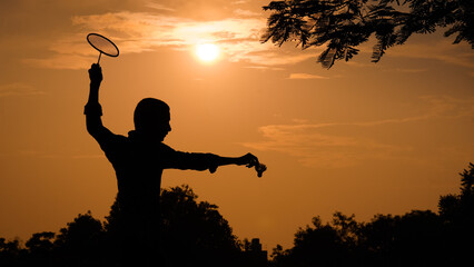 silhouettes Man is holding the shuttlecock and the badminton racket