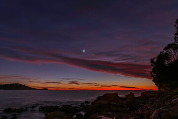 First light over the ocean with 9 percent sliver of moon and stars