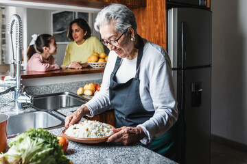 Hispanic grandmother cooking at home kitchen in Mexico Latin America