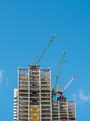Building under construction, cranes and high-rise building