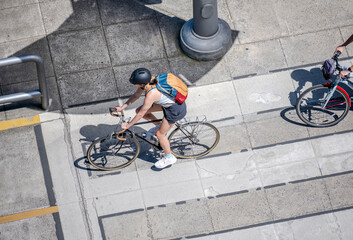 Cyclists who enjoy an active lifestyle ride along a dedicated bike path on the street of a summer urban city