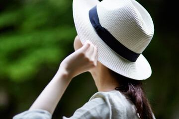 自然の中で佇む日本人女性と麦わら帽子