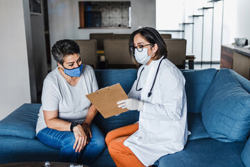 Hispanic female Doctor giving Covid vaccine to senior woman in her home in Mexico Latin America