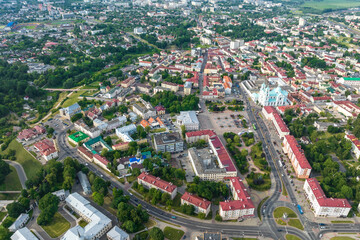 aerial panoramic view from great height on red roofs of old big city with skyscrapers and white fluffy clouds