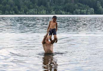 father and son swim in a pond