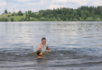 Fototapeta na wymiar father and son swim in a pond