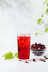 A refreshing drink made of dried hibiscus leaves and ice in a glass.