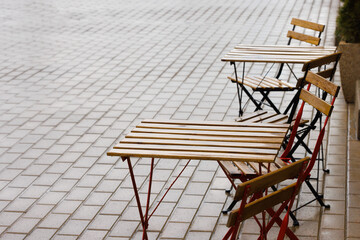 Wet tables and chairs of a summer cafe after rain. Place for text. Copyspace. Selective focus.