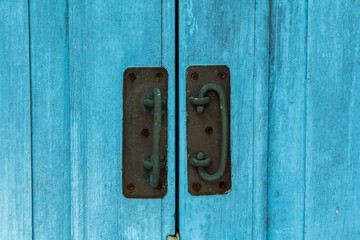 light blue wooden door with steel gongs as a lock to prevent thieves and burglars from coming in. Contemporary vintage wooden doors are solid wood for door making.
