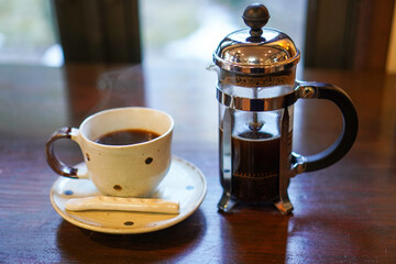 French pressed dark coffee on wood table