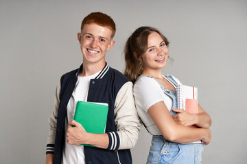 Portrait of smiling girl and boy standing at grey background