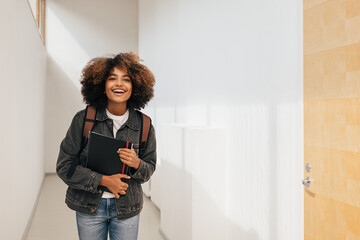 Fototapeta Laughing girl in casuals walking in college corridor obraz