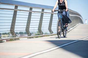Fototapeta na wymiar Woman cyclist takes care of her health and rides her bike along the bike path at Tilikum Crossing Bridge in Portland