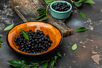 Superfoods antioxidant of indian mapuche. Bowl of fresh maqui berry on dark background, top view