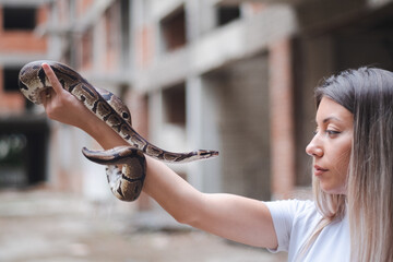 Long hair woman and a snake in the urban environment