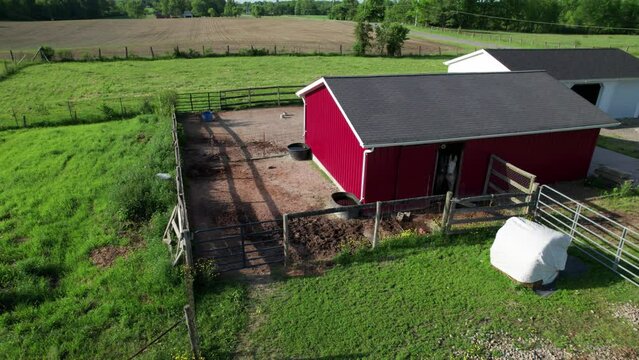 A static view of a beautiful barn yard. The barn is painted in red and built in the middle of the field