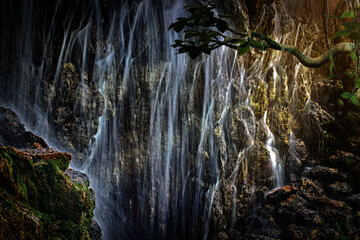 A large waterfall in the sun's rays tropical mysterious fairy jungle