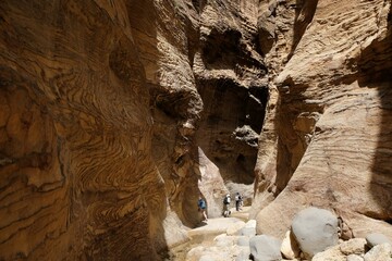 Dana Biosphere Reserve in Jordan. Amazing rocks in Wadi Ghuweir Canyon. Silhouette of hiking person on trail. 