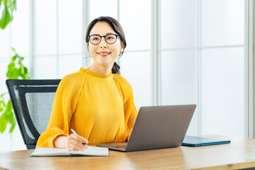 モダンなオフィスでノートパソコンを使う女性