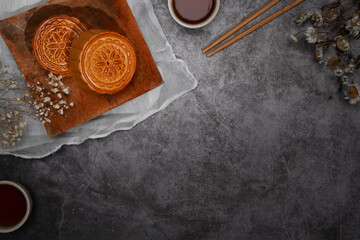 Top view traditional mooncakes on dark stone background, for Chinese mid Autumn festival celebration