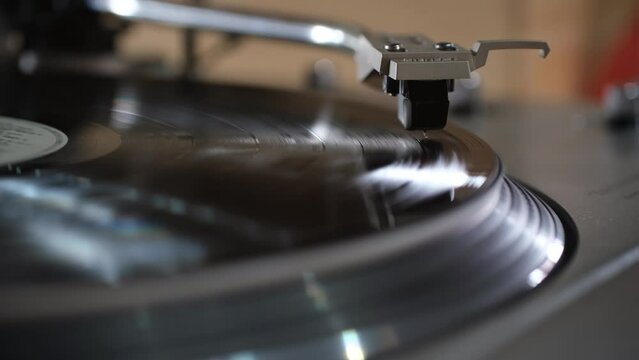 Focus on Stylus of Headshell of Classic Vintage Vinyl Record Player Playing on Vinyl Record Music
