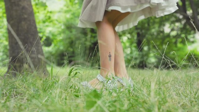 Children's education and curiosity. Cute little girl in a straw hat looks at the grass through a magnifying glass. Low angle view, slow motion. The concept of scouting and childhood.