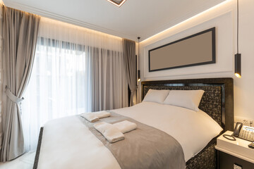 Interior of a luxury double bed hotel bedroom with black and white furniture