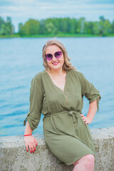 Happy woman of plus size, walks in the city enjoying life. Young lady with excess weight, stylishly dressed at the city park .Natural beauty