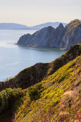 View of the rocky cape and mountains. Beautiful landscape. Natural landmark of the Magadan region. Journey to the Far East of Russia. Cape Nyuklya, coast of the Sea of Okhotsk, Magadan region, Russia.