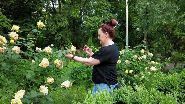 Woman photographing flowers with her phone