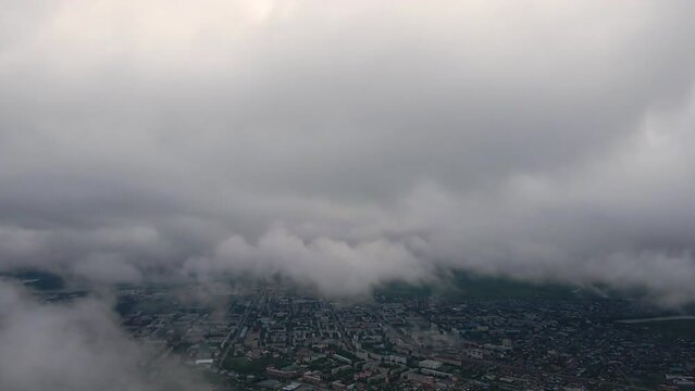 Flying through thick clouds. Rain clouds in the sky. Cumulus clouds, meteorology and climate studies.Video of the city from the height of clouds, aerial photography.Quadcopter,drone