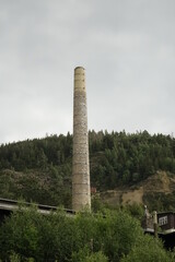 Chimney of Rammelsberg visitor mine, UNESCO World Heritage site under a cloudy spring sky, concept: industrial, vintage (vertical), Goslar, Lower Saxony, Germany