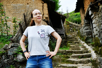 an Asian lady standing in front of an old house, China, Zhejiang Province