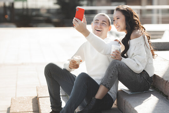 Young multiracial couple making selfie picture on cell phone. Man and woman having fun together. Young people talking on a smartphone.