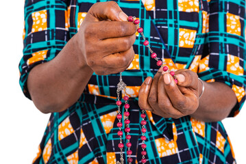 Christian woman praying with hands holding rosary beads.