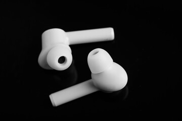 Technology concept : wireless ear bud or headphone on black background.